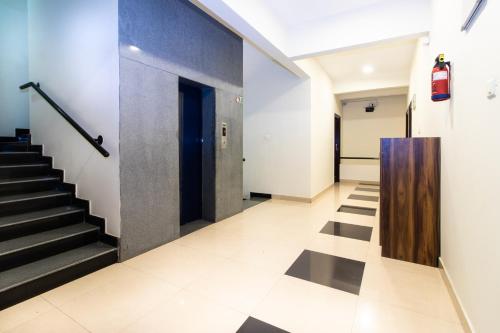 a hallway with stairs and a blue door at Sanctum Suites Indiranagar Bangalore in Bengaluru