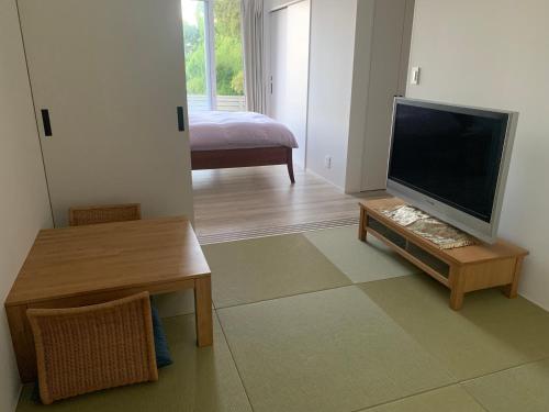 a living room with a flat screen tv on a table at Yugawara Vacation House in Yugawara