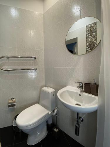 a bathroom with a white toilet and a sink at 555 метров до моря in Liepāja