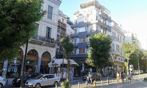 a large building on a city street with cars parked at CKBSM Athens Center Apartment 2 in Athens