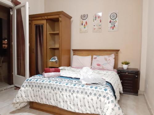 a bedroom with a bed with a wooden headboard at Family Apartment - Downtown Cairo in Cairo