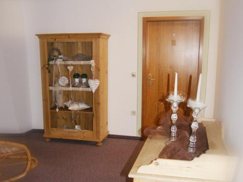 a room with a wooden cabinet and a table with candles at Zum Bräu-Toni in Dietfurt