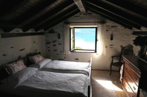 1 dormitorio con cama y ventana en Rustico Storelli, en Brissago