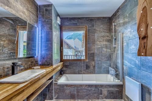 baño con bañera, lavabo y ventana en Charmant Appartement Lac d'Annecy / Ski - 6 Pers, en Menthon-Saint-Bernard