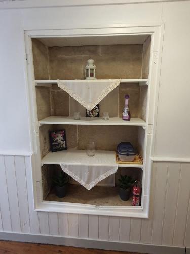 a book shelf in a room with a window at Maison d'hôtes du Faubourg Charrault Saint Maixent L'Ecole in Saint-Maixent-lʼÉcole