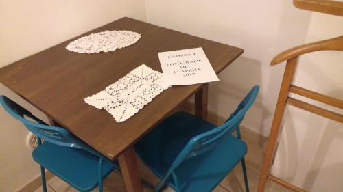 a wooden table with two blue chairs and a sign on it at Cinque Terre Tra Il Filo Di Arianna in Riccò del Golfo di Spezia