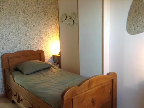 a bedroom with a wooden bed in a room at BLUE SEJOUR 14 in Saint-Aubin-sur-Mer