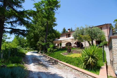 a house with a garden and a dirt road at Agriturismo Biologico Villa Rosa in Monte Guiduccio