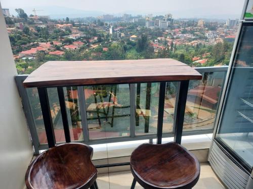 uma mesa e duas cadeiras em frente a uma janela em Prince Studio @ Twiga House em Kigali