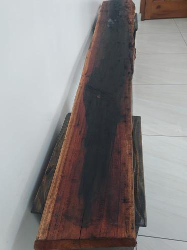 um banco de madeira sentado no chão ao lado de uma parede em Prince Studio @ Twiga House em Kigali