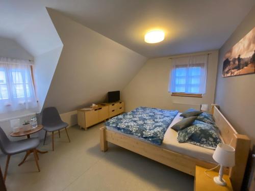 a bedroom with a bed and a table and chairs at Penzion a restaurace Grunt in Řeka