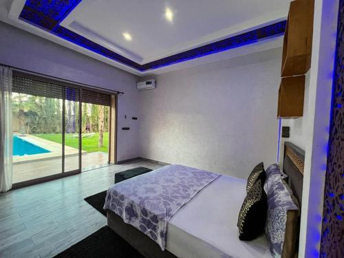 Schlafzimmer mit einem Bett und Poolblick in der Unterkunft agafay villa in Marrakesch