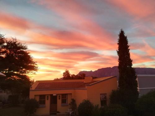 a house with a sunset in the background at Worcester Garden Cottage in Worcester