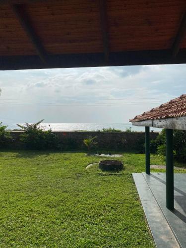 a view of a yard with the ocean in the background at Spice of Ceylon in Chilaw