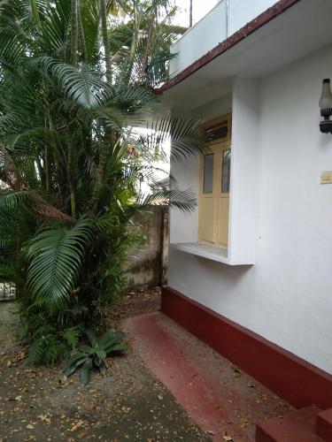 un edificio blanco con una ventana y una palmera en C. L Inn, en Kochi