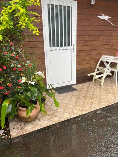 a white door of a house with a table and flowers at LaKour Fleurie Chambres d hôtes in Sainte-Rose