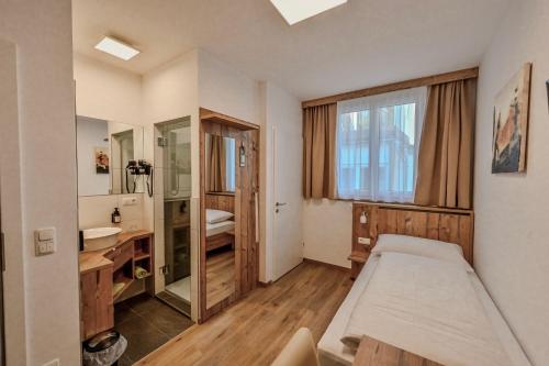 a bedroom with a bed and a sink and a mirror at City Rooms Wels - contactless check-in in Wels