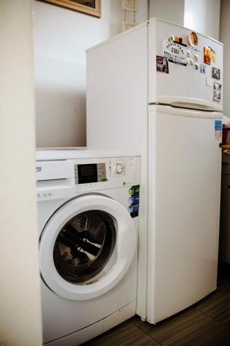 a white washing machine next to a refrigerator at Big Garden House in Dunajská Streda