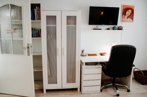 a room with a desk with a computer and a chair at Big Garden House in Dunajská Streda