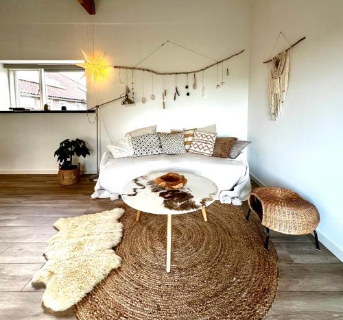 a bedroom with a bed and a table and a rug at The Smiling Buddha in Achthuizen