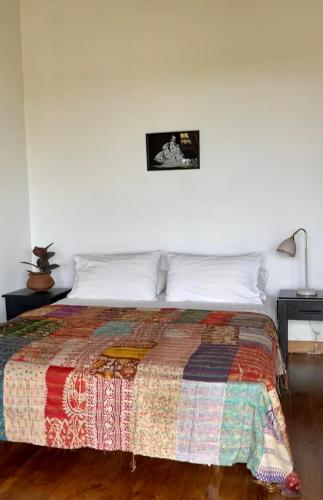 a bedroom with a bed with a quilt on it at Spice of Ceylon in Chilaw