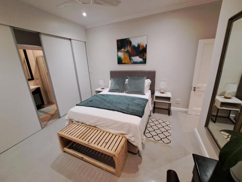 a bedroom with a bed in a white room at Spray Villa Bloubergstrand with hot tub and close to the beach in Bloubergstrand