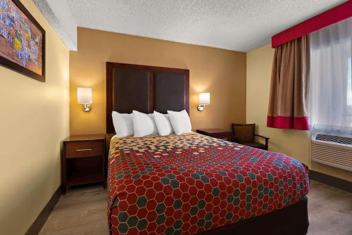 a hotel room with a bed and a window at Kings House Motor Hotel in Flagstaff