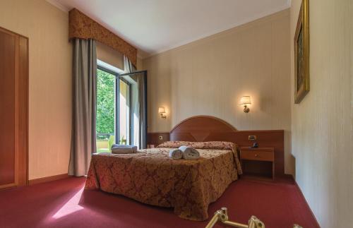 Postel nebo postele na pokoji v ubytování Hotel Columbus sul Lago