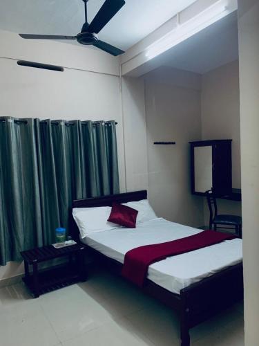 sypialnia z łóżkiem i wentylatorem sufitowym w obiekcie M square residency w mieście Kalpatta