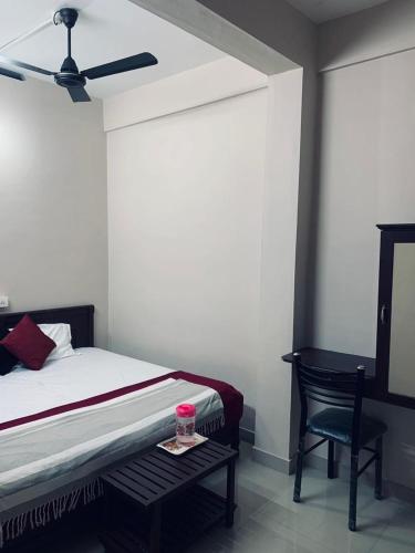 a bedroom with a bed and a table and a chair at M square residency in Kalpetta