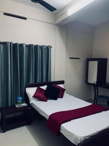 sypialnia z 2 łóżkami i zielonymi zasłonami w obiekcie M square residency w mieście Kalpatta