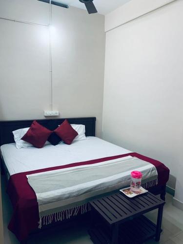 a bedroom with a bed with red pillows at M square residency in Kalpetta