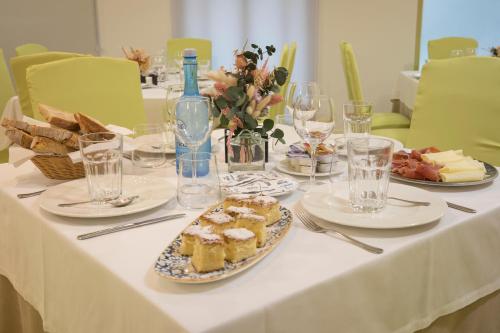 a table with plates of food and wine glasses at Hotel Roma in Sarria