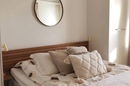 Dormitorio con cama con espejo y almohadas en Verso la casa mia en Helsinki