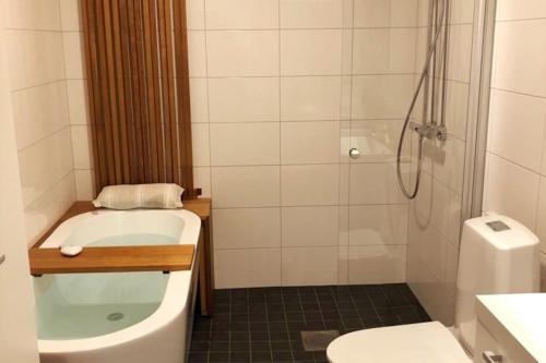 y baño con bañera, aseo y ducha. en Verso la casa mia en Helsinki