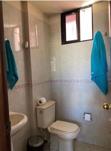 Cómoda Suite + piscina في كوتشابامبا: حمام مع مرحاض ومغسلة ونافذة