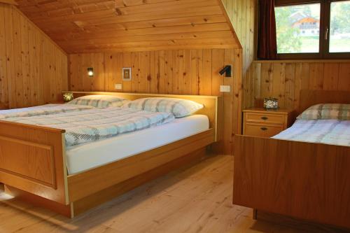 um quarto com 2 camas num chalé de madeira em Ciasa Alfri em La Villa