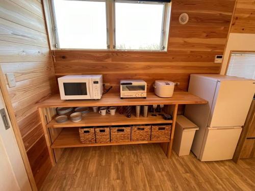 a kitchen with a counter with two microwaves and a refrigerator at Blu Pointe in Minamiboso