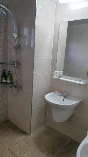 a bathroom with a sink and a shower at Geoje Seaside Two floors Villa in Geoje