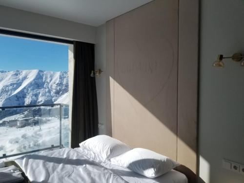 a bedroom with a bed with a view of a mountain at Segreto apartment 309, 311, 341 in Gudauri