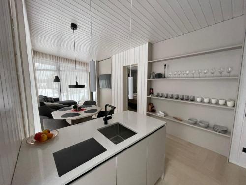 a kitchen and living room with a sink and a table at Tondikaku Holiday Home in Otepää