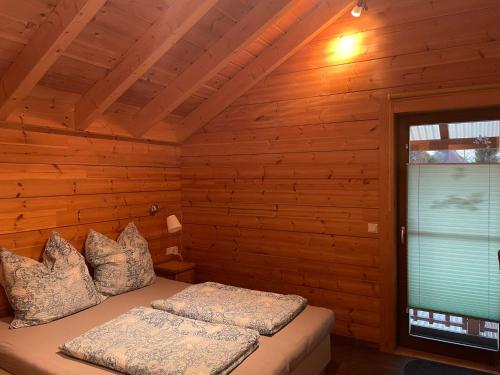 a bedroom with a bed in a log cabin at Gästehaus Carpe Diem in Kappel-Grafenhausen