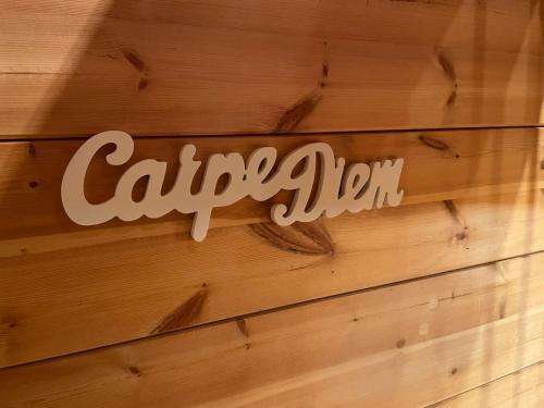 a sign on the side of a wooden wall at Gästehaus Carpe Diem in Kappel-Grafenhausen