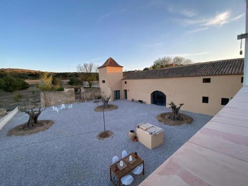 a courtyard with white chairs and a building at Finca Las Botas in Almansa