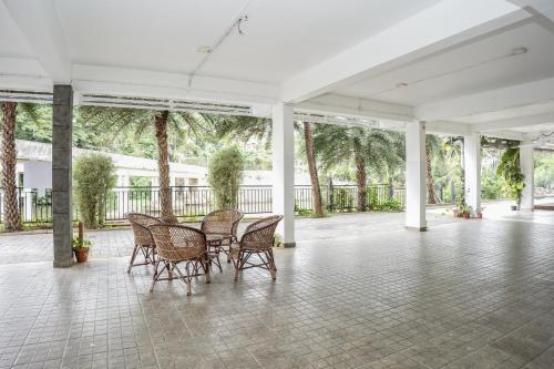 a patio with a table and chairs on a tile floor at HOTEL LETS STAY in Ernakulam