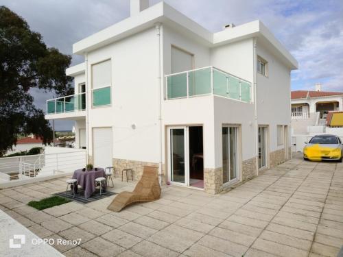 une maison blanche avec une voiture jaune garée devant elle dans l'établissement Residencial Monte Gordo Golf Rei Algarve, à Monte Gordo