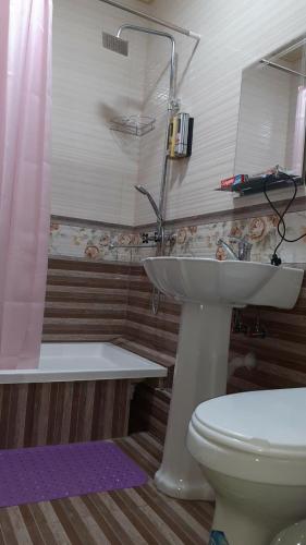 a bathroom with a toilet and a sink and a shower at Ikkinchi, keraksiz in Min-Bulak