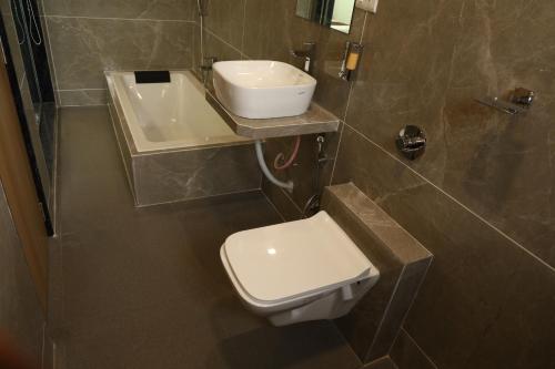 Hotel Yuvika Residency في نافي مومباي: حمام مع مرحاض ومغسلة