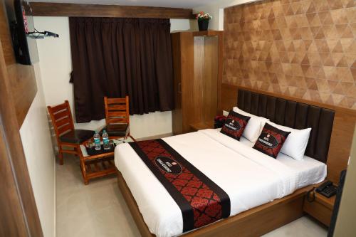 Hotel Yuvika Residency في نافي مومباي: غرفة نوم بسرير وطاولة وكرسي