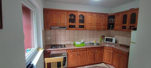 a kitchen with wooden cabinets and a sink and a microwave at Fenix in Sarajevo